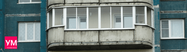 Длинный прямой балкон с закруглениями с двух сторон в панельном доме 137 серии. Остеклён алюминиевыми раздвижными окнами. 