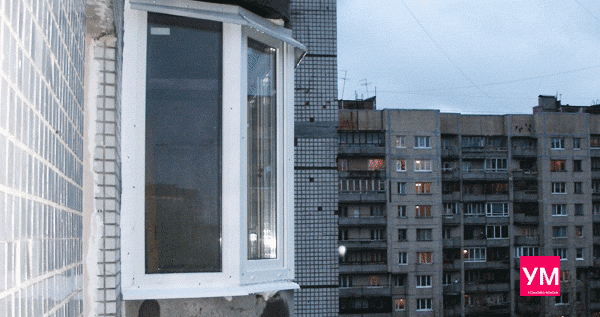 Вид балкона вблизи со стороны улицы. Показан эркерный изгиб остекления, соединения оконных рам