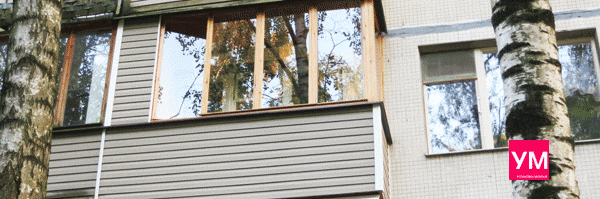 Трёхметровый Г-образный балкон остеклен деревянными рамами и окнами в одно стекло 4 мм. Снаружи обшит виниловым сайдингом белого цвета. Слева установлен шкафчик.