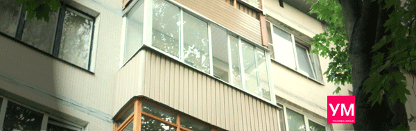 Алюминиевый П-образный балкон длиной три метра. Белого цвета. Снизу обшит вертикальным виниловым сайдингом.