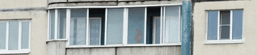 Балкон с закруглением остеклён алюминиевыми раздвижными окнами белого цвета