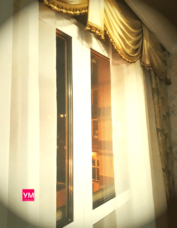 Оформление французского балкона с белыми двустворчатыми дверями тяжелыми золотыми шторами 
