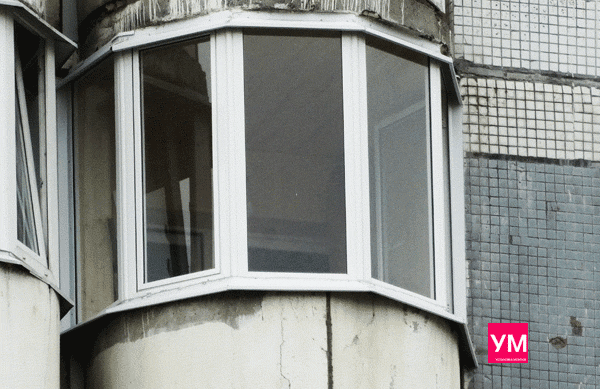 Круглый балкон остеклнён узкими окнами с эркерными соединителями