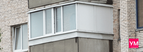 Белый большой угловой балкон остеклен пластиковыми окнами со стеклопакетами. Справа сделана глухая стена из сендвич панели для создания зоны хранения вещей, шкафчика и антресолей.