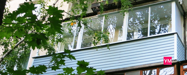 Балкон остеклён раздвижными окнами и обшит с внешней стороны сайдингом.