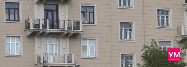 Фрагмент многоквартирного дома Сталинского времени постройки. Красивые балконы с большими окнами и дверями. Остекления нет, фасад охраняется историей. 