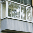 Остеклённый раздвижными алюминиевыми окнами балкон белого цвета в Хрущёвке