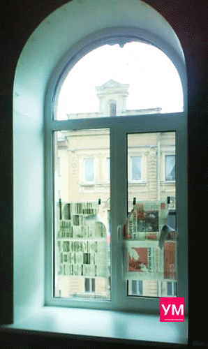 Арочное белое окно установлено под ключ, с подоконником и откосами. 