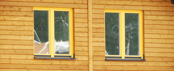 Два двухстворчатых окна покрашенных жёлтой краской. Установлены в каркасном доме