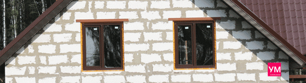 Установлены два коричневых двухстворчатых окна в процессе строительства загородного дома