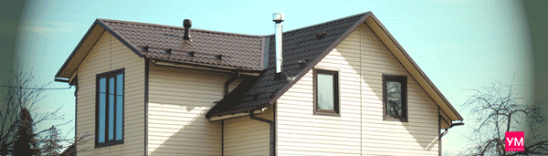 Загородный дом обшитый виниловым сайдингом бежевого цвета и с установленными коричневыми пластиковыми окнами