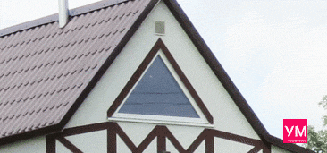 Белое треугольное глухое окно, установленное под коньком крыши загородного дома