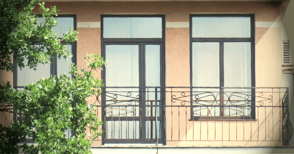 Окна и дверь выхода на балкон ламинированы чёрной плёнкой и установлены в многоэтажном доме