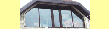 Трапециевидное окно коричневого цвета, с открывающейся створкой в середине конструкции.