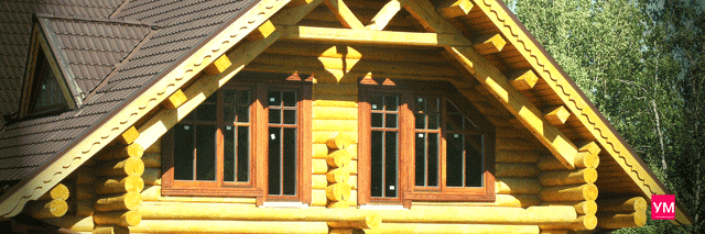 Загородный дом из бревна с установленными ламинированными пластиковыми окнами с декором