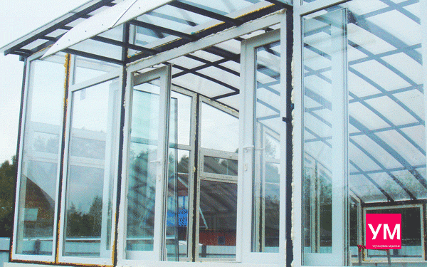 Пластиковая раздвижная дверь в открытом состоянии, установленная в бассейне. Стены из стекла. Крыша полупрозрачная. 